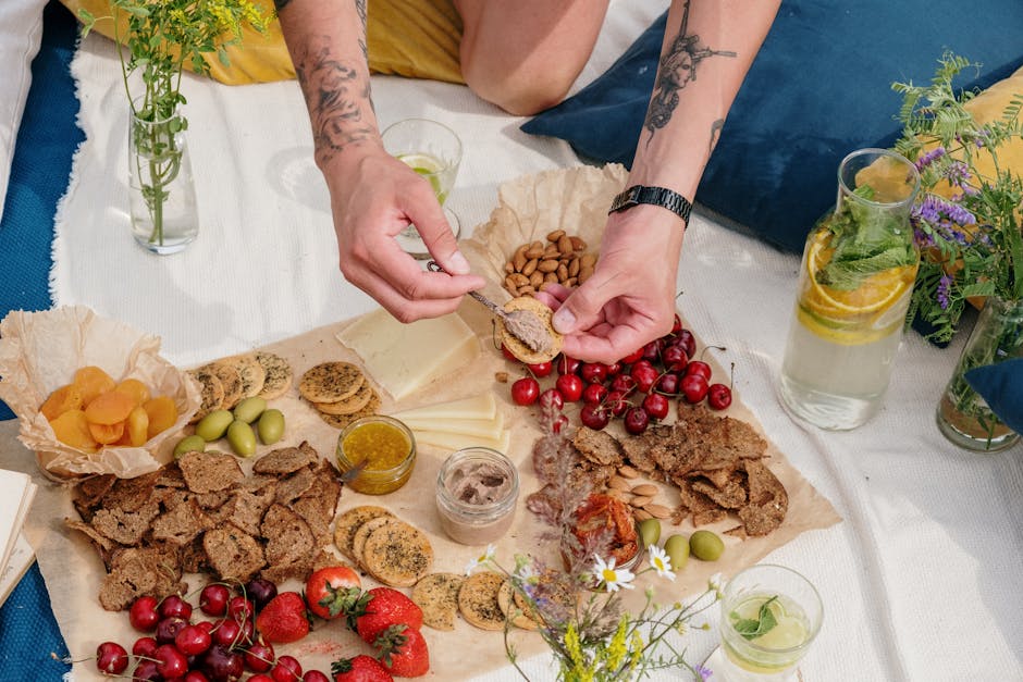 Plant-based foods arranged on a wooden table — beans, grains, leafy greens, fruits, nuts