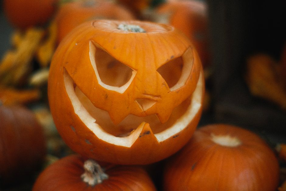 Carved jack-o'-lantern sitting on a pile of pumpkins