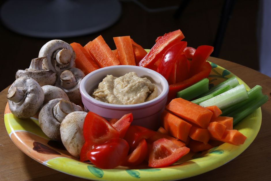 Platter of hummus with carrots, peppers, celery and mushrooms